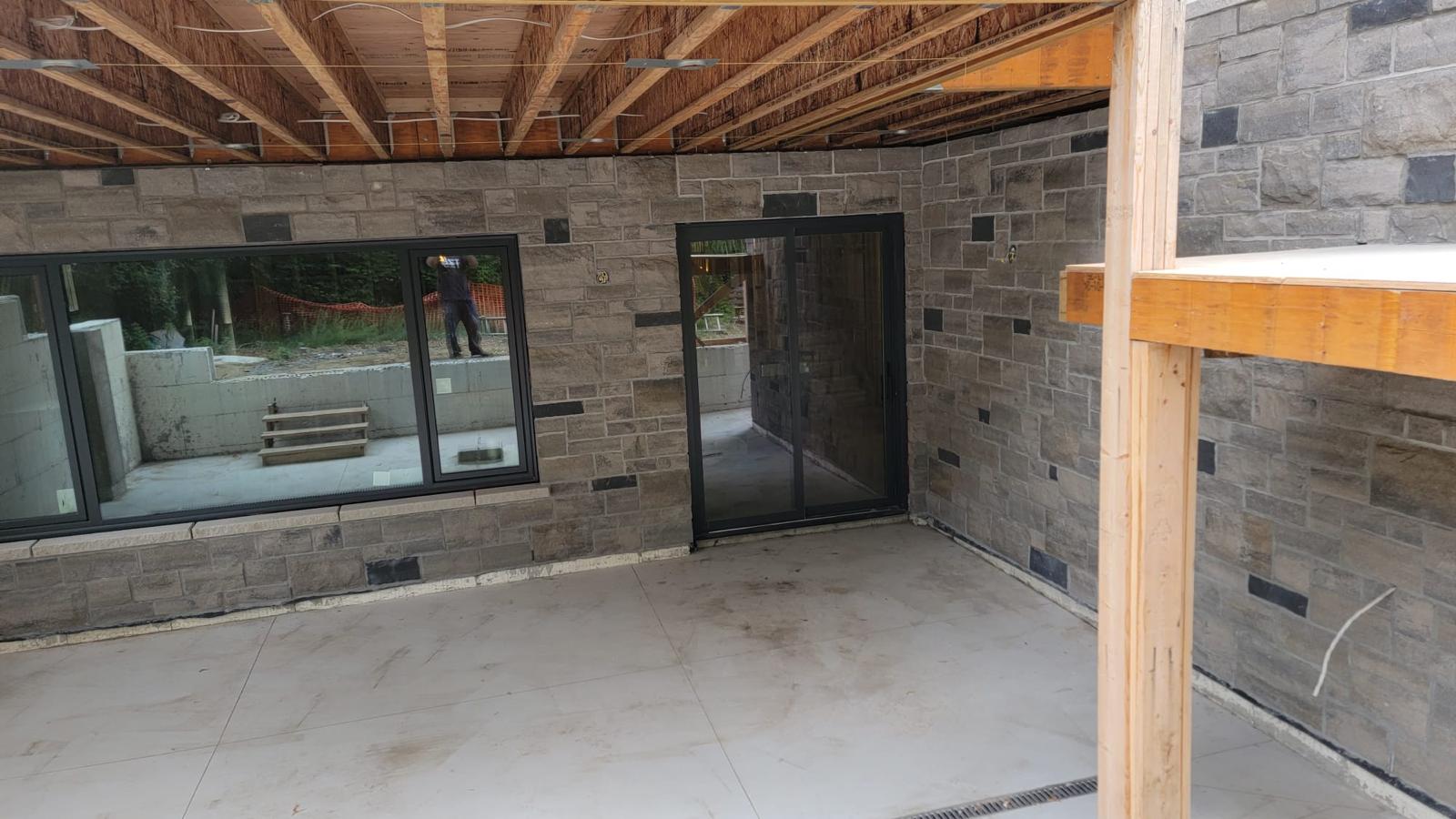 Covered stone courtyard with glass sliding door