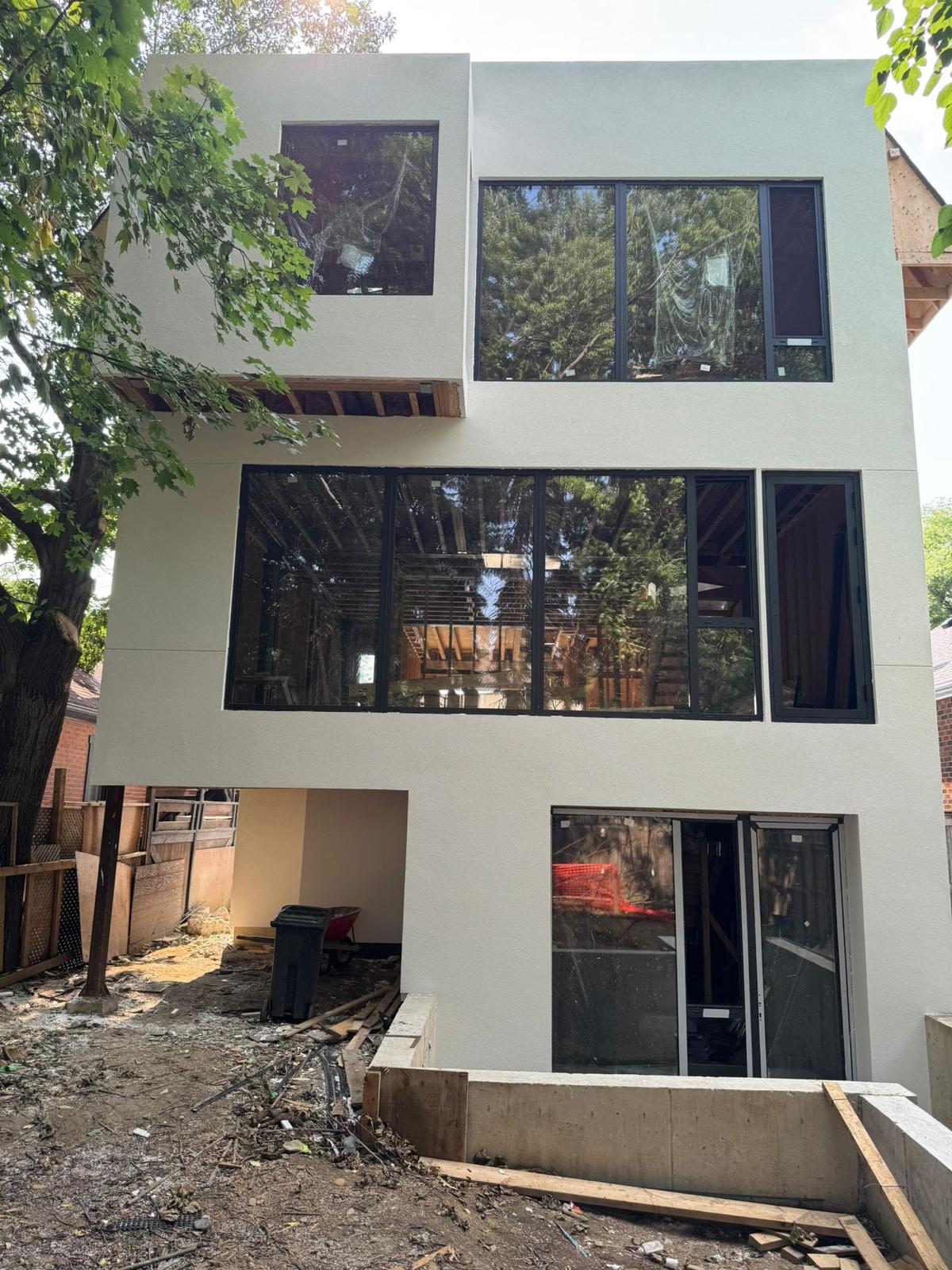 Modern boxy stucco rear elevation with black-framed windows