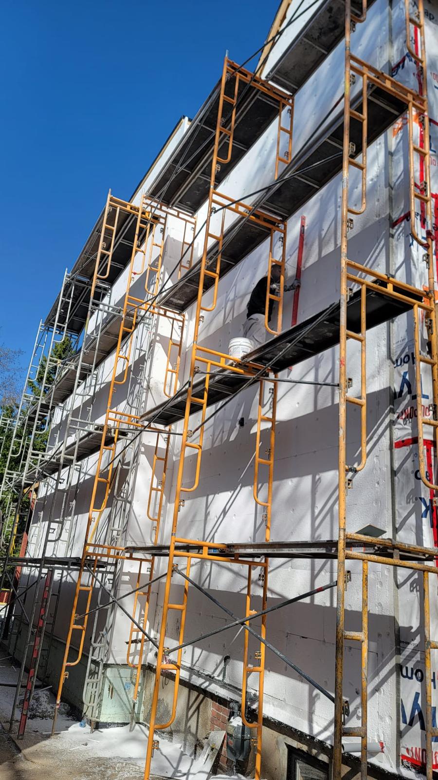 Scaffolding and house-wrap during stucco preparation